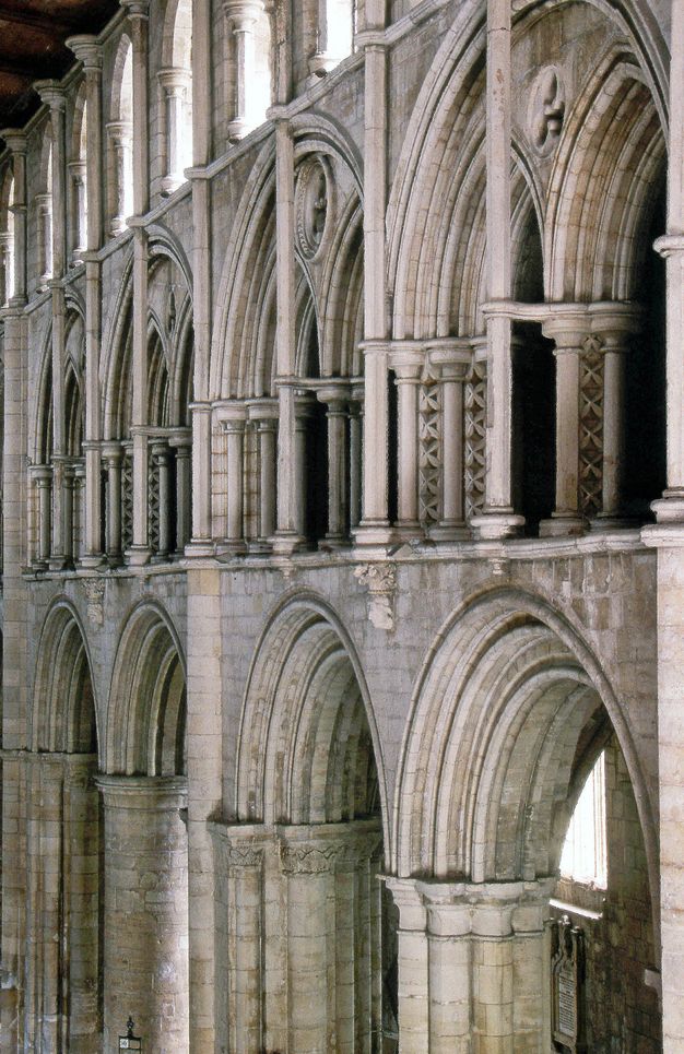 Architecture. Three levels of stone arches angle away from us to the left in this church interior. Detached shafts, commonly likened to flagpoles, have been added in front of the double arches on the middle level.